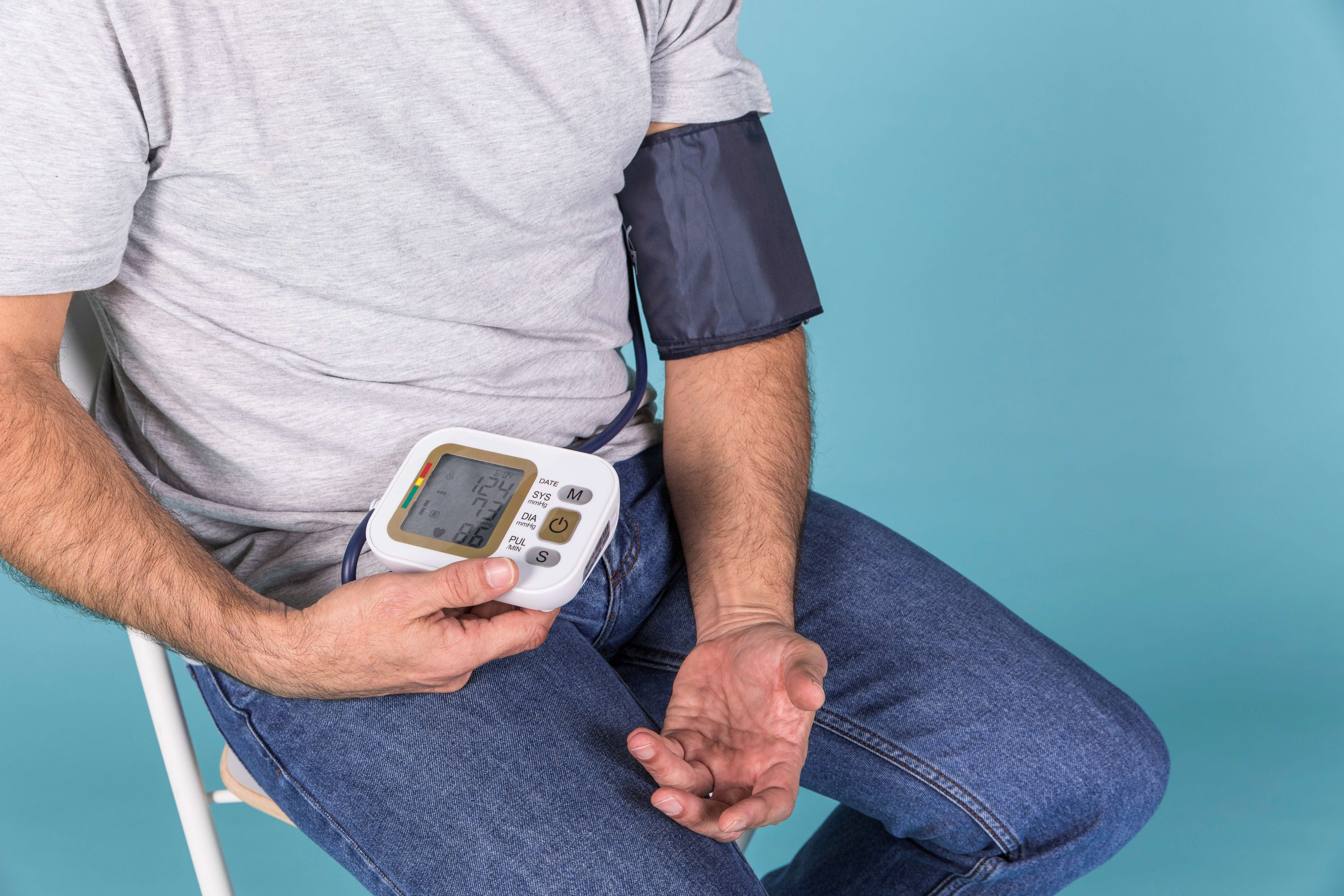Patient taking blood pressure with device.